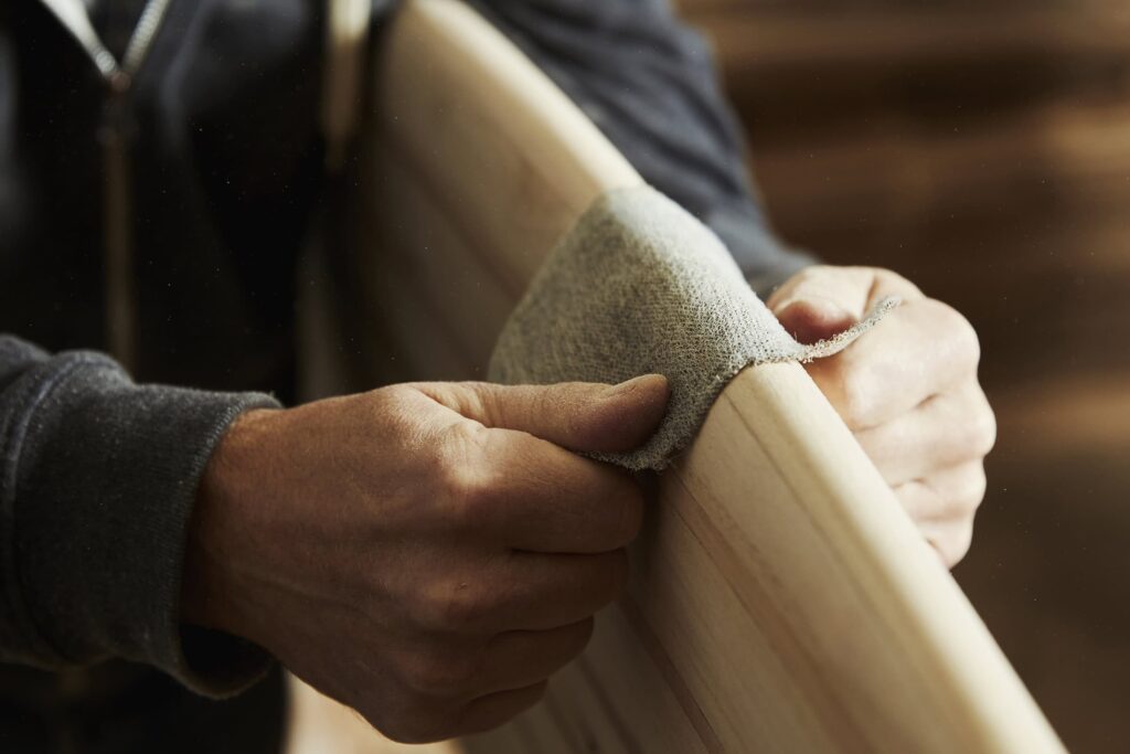 hands sanding the edge of a wooden board for a handmade valentine gift